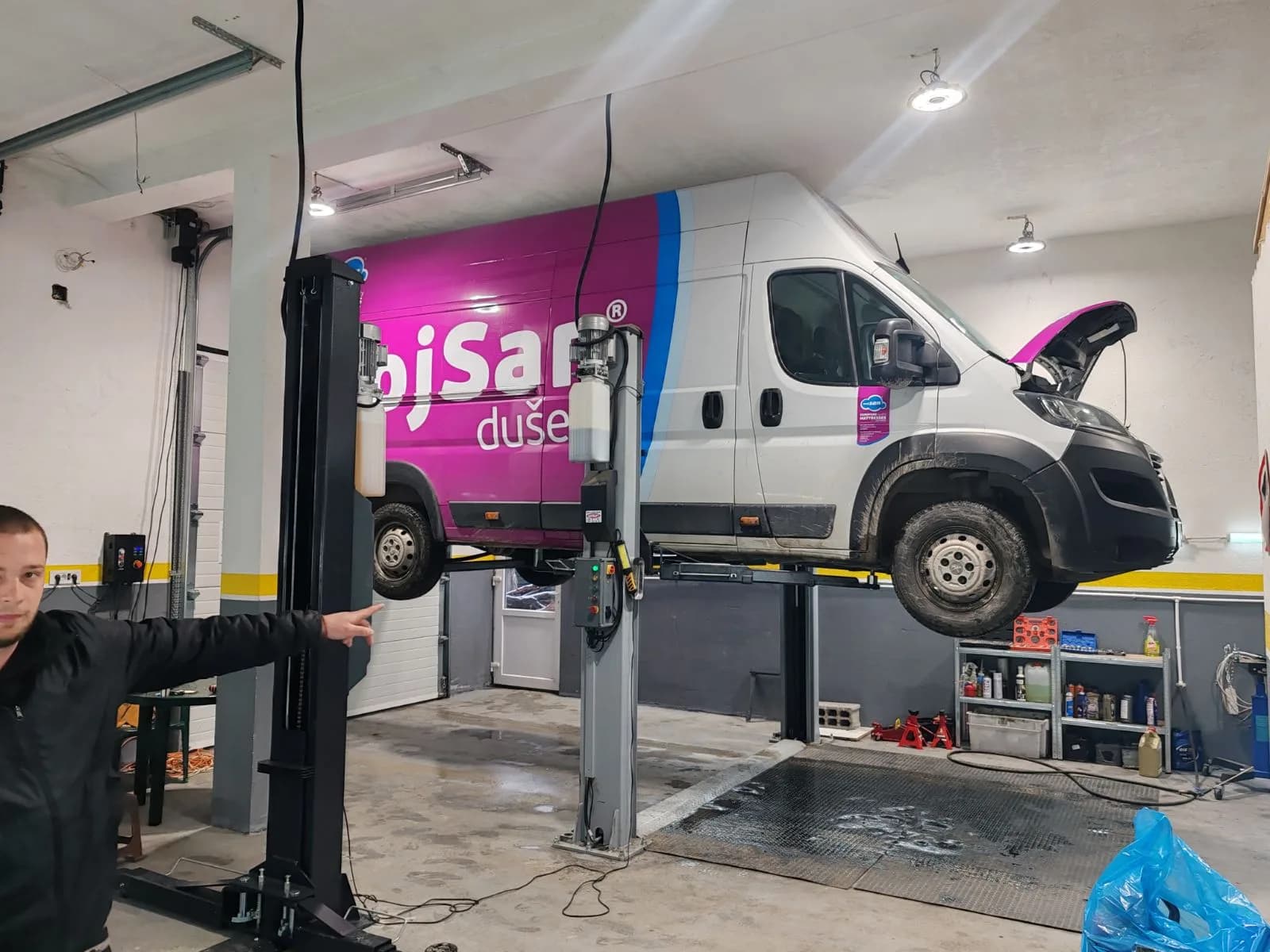 Paja podiže komercijalno vozilo na hidraulični lift u radionici